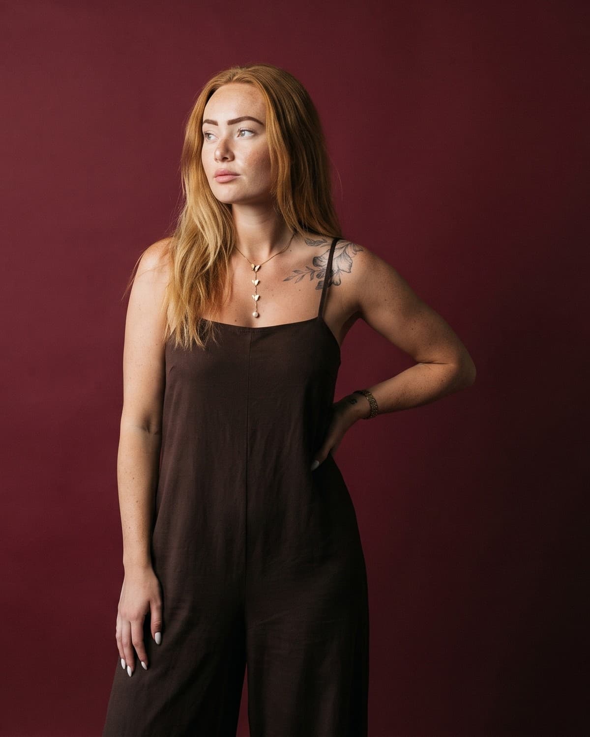 Portrait of Line, co-founder of Plant, standing against a deep burgundy studio backdrop.